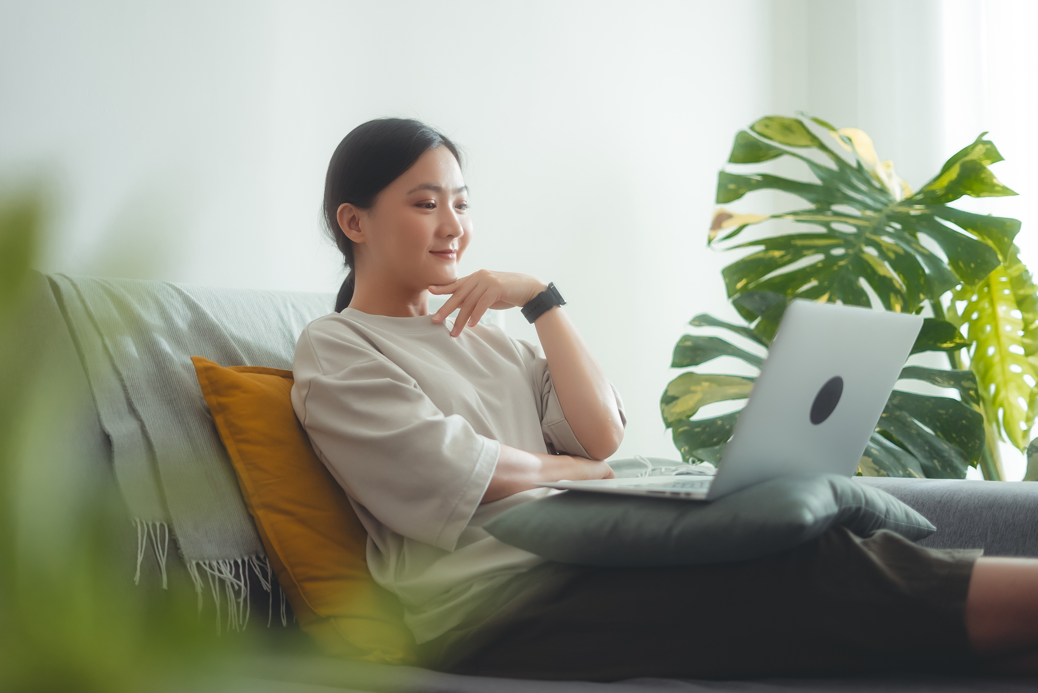 Asian woman enjoying using laptop talking on video conference at home.